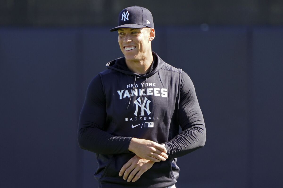 New York Yankees outfielder Aaron Judge shares a laugh with teammates during a spring training baseball workout, Monday, March 14, 2022, in Tampa, Fla. (AP Photo/John Raoux)