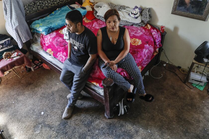 Los Angeles, CA, Wednesday, November 16, 2022 - Ruth Perez, 47, and her son, Yonathan, 23, inside a bedroom with deeply soiled and old carpet at the Chesapeake Apartments, The Chesapeake is a large housing complex in South Los Angeles.which is owned by a landlord who has faced significant scrutiny over slum conditions at many of his buildings across Southern California, has had severe habitability issues, including mold and faulty plumbing. The city recently postponed putting the complex in a program that reduces rent for tenants living in problem properties. Tenants say their issues continue to persist. (Robert Gauthier/Los Angeles Times)
