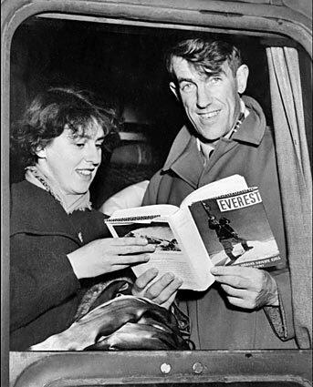 In January 1954, Hillary and his wife, Louise, display a book about his Everest achievement as they arrive by train in Val D'Isere, France.