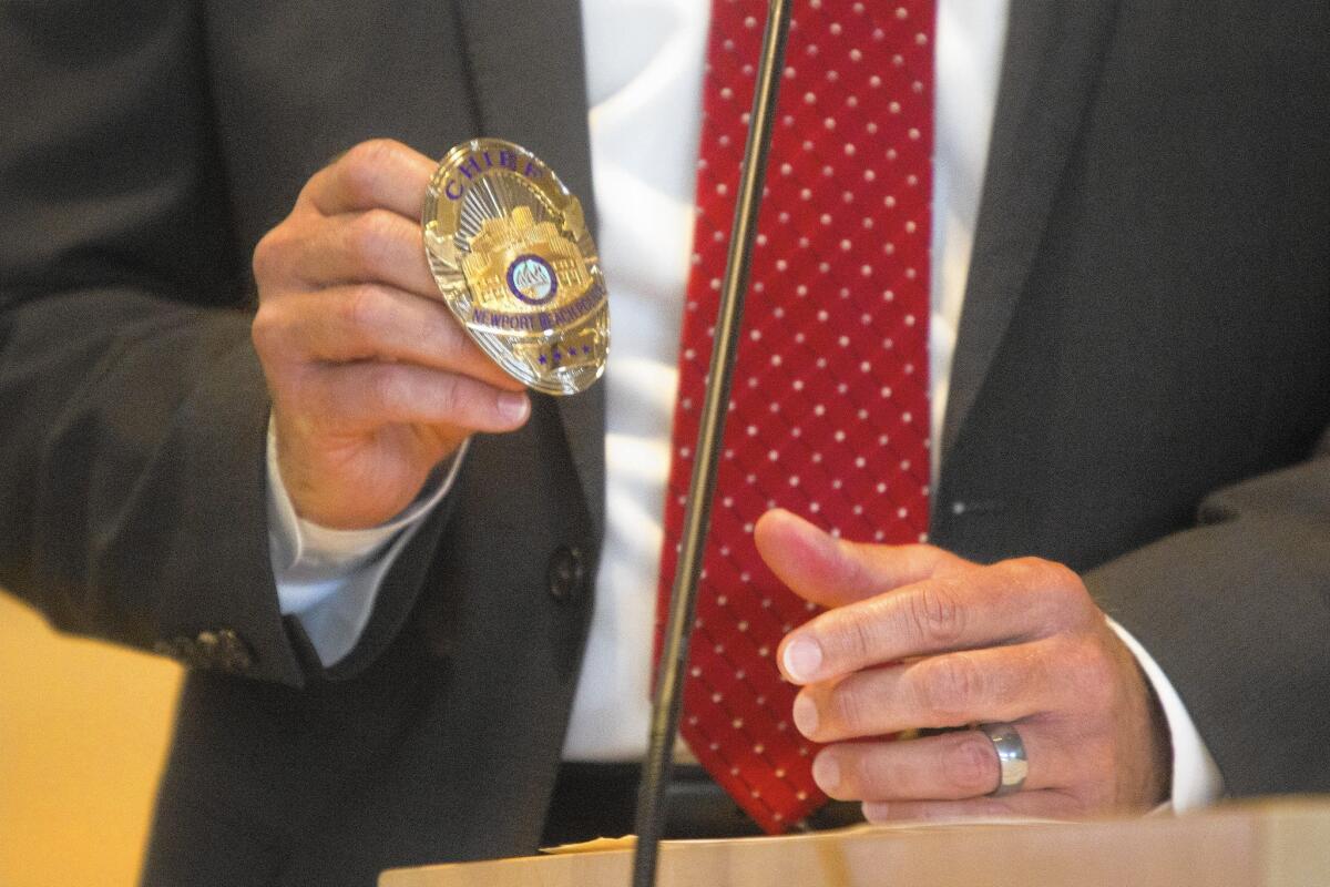 Retiring Newport Beach Police Chief Jay Johnson describes the importance of the badge during the swearing in ceremony for Jon Lewis on Tuesday afternoon.