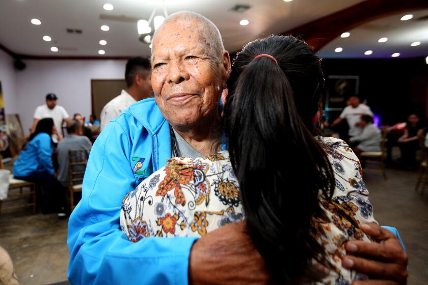 Ninety-year old Ignacio Mendoza, from Zacatepec, Mexico, hugs a relative he hasn't seen in decades.