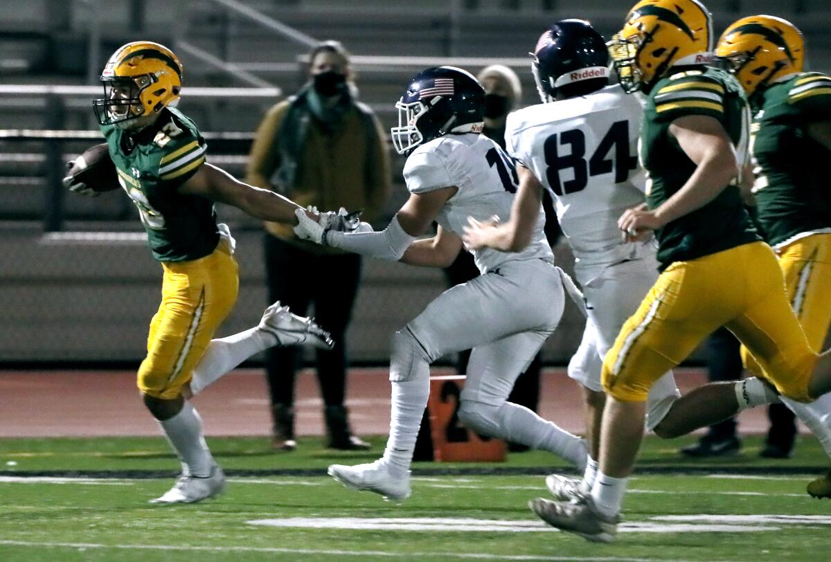 Edison's Nico Brown gets caught by an arm by a Newport Harbor defender.