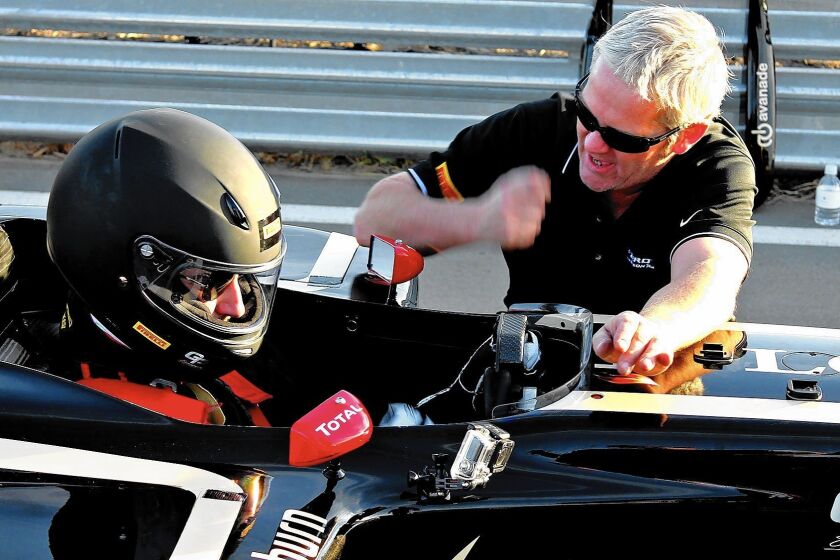 The GP Experience staff prep David Undercoffler in a Formula One race car prior to heading onto the track.