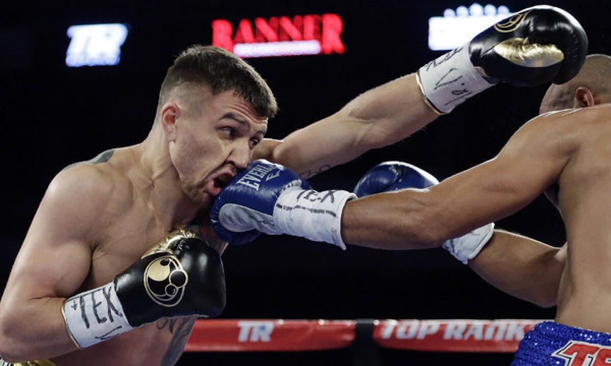 Vasyl Lomachenko, left, throws a left jab as he takes a punch from by Orlando Salido in their featherweight fight on Saturday. Lomachenko lost in a split decision.