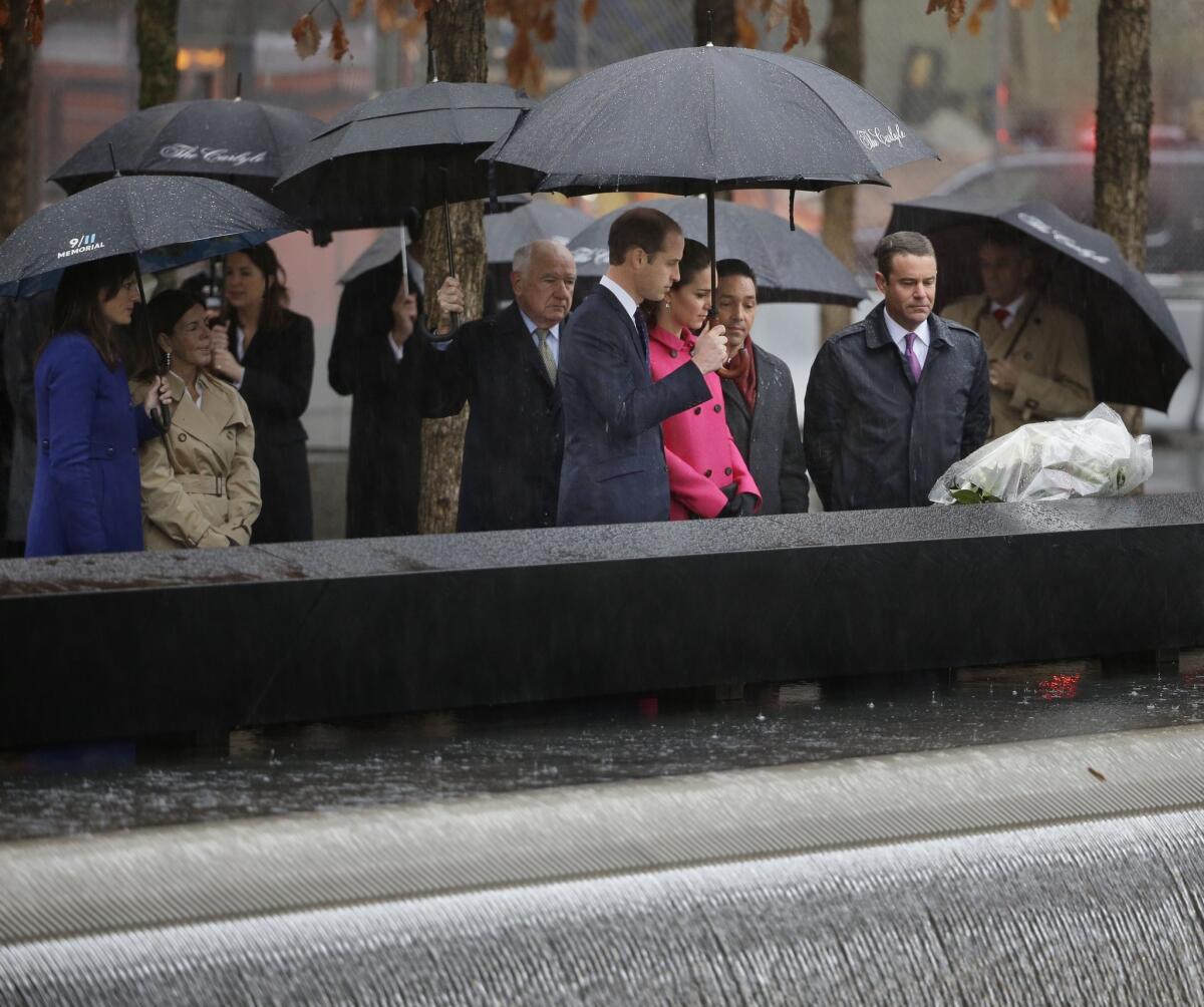 Britain's Prince William and Kate, Duchess of Cambridge, center, observe a moment of silence after laying flowers at the edge of a memorial pool at the National September 11 Memorial in New York on Dec. 9.