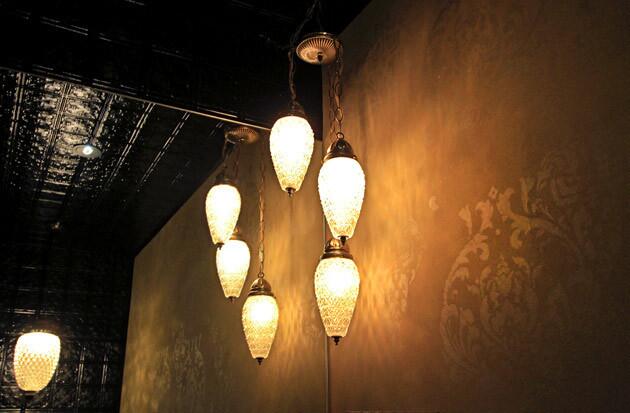 Vintage lamps in the powder room illuminate a subtle stencil pattern on the walls and tin tiles on the ceiling. Other touches of vintage design throughout the house came from flea markets and antique stores.