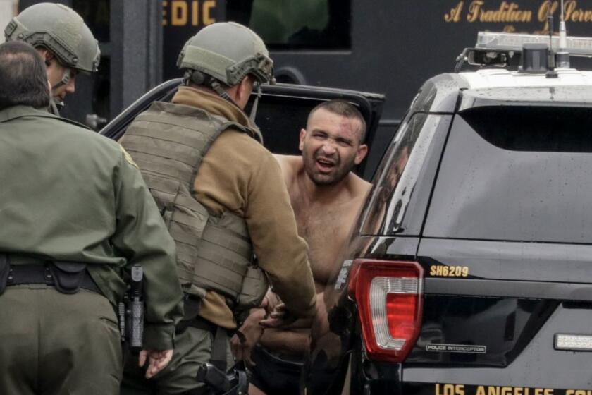 L.A. County sheriff's deputies escort Isaias De Jesus Valencia, suspected of fatally shooting a Pomona police officer.