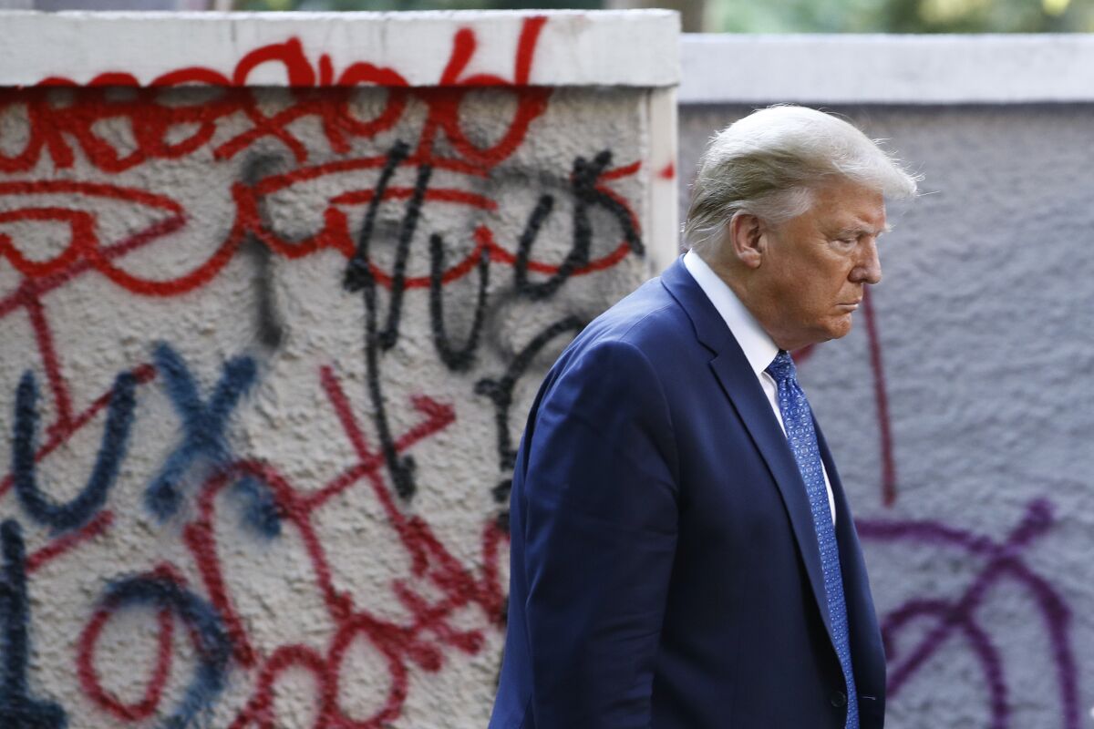 President Trump passes graffiti at Lafayette Park en route to a photo op at St. John's Episcopal Church in Washington.