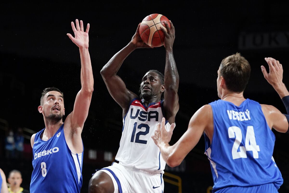 United States's Jrue Holiday (12) drives to the basket between the Czech Republic's Tomas Satoransky (8) and Jan Vesely (24) during a men's basketball preliminary round game at the 2020 Summer Olympics, Saturday, July 31, 2021, in Saitama, Japan. (AP Photo/Charlie Neibergall)