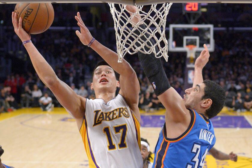 Lakers point guard Jeremy Lin goes up for a shot at the rim despite the presence of Thunder center Enes Kanter.