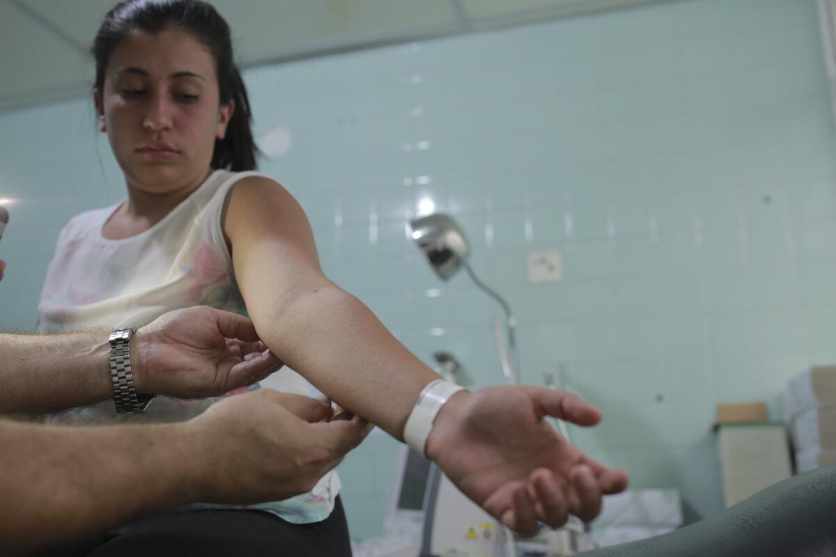 A gynecologist examines a rash on the arm of Daniela Rodriguez, 19, who is six weeks pregnant and was diagnosed with the Zika virus at the Erasmo Meoz Hospital in Cucuta, Colombia.