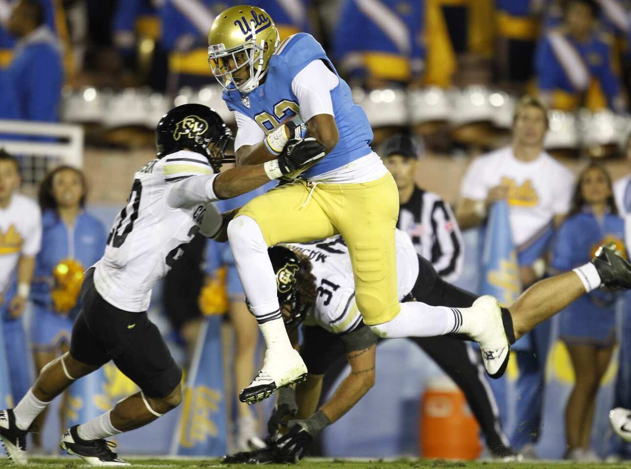 Bruins receiver Nelson Rosario gets past Buffaloes defensive back Greg Henderson for a touchdown in the second half Saturday at the Rose Bowl.