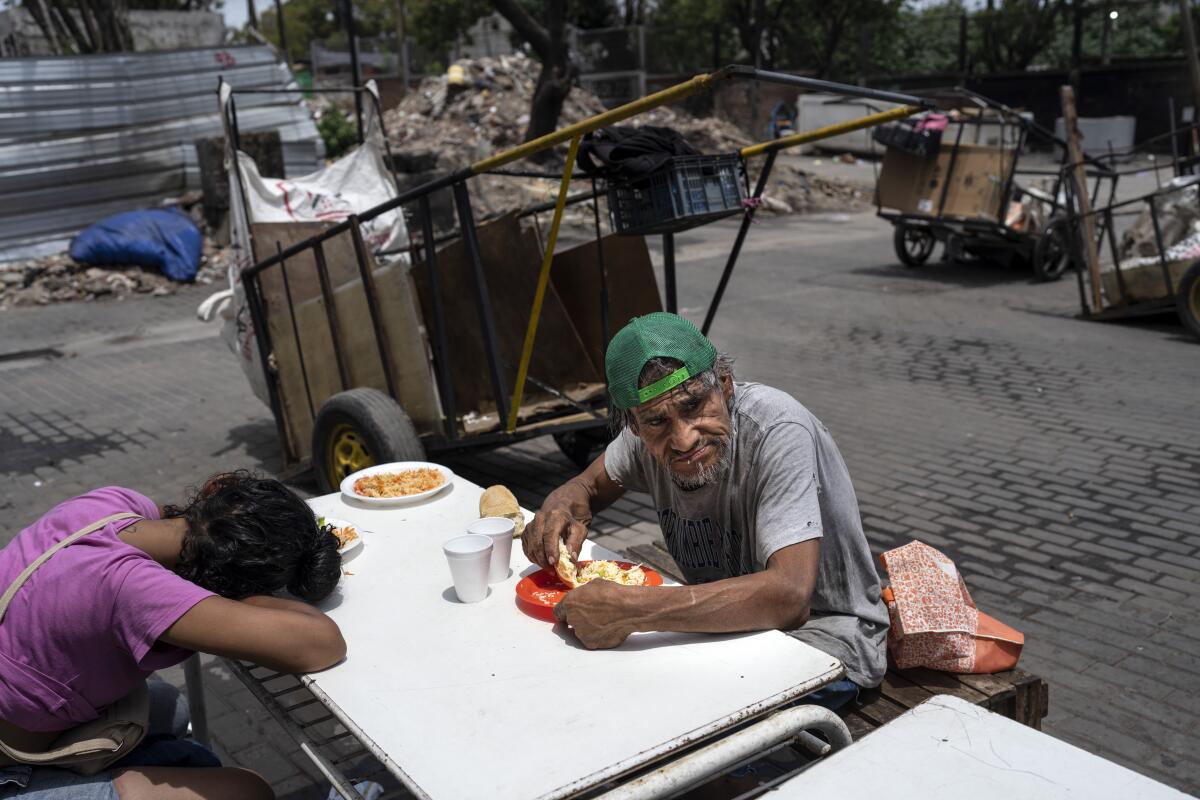 Dos personas almorzando una comida gratuita en Buenos Aires.