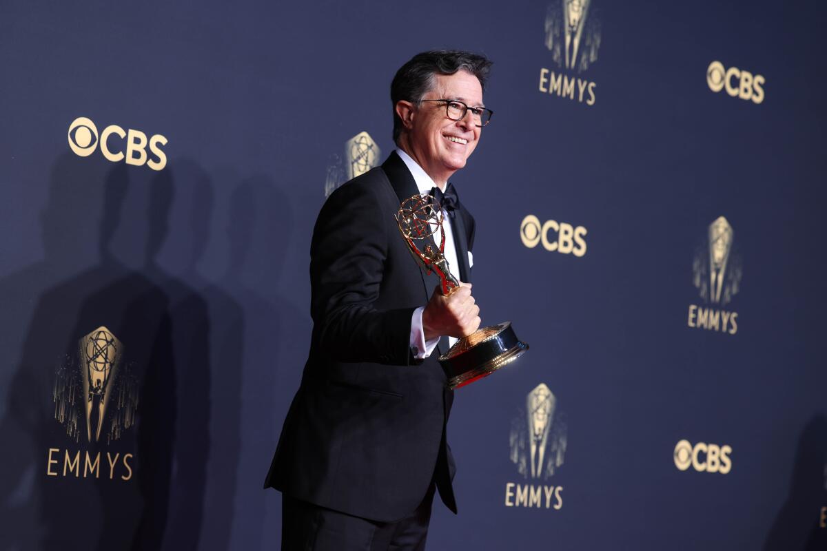 A man in a tuxedo holds an Emmy statuette in front of a step-and-repeat CBS/Emmys backdrop.