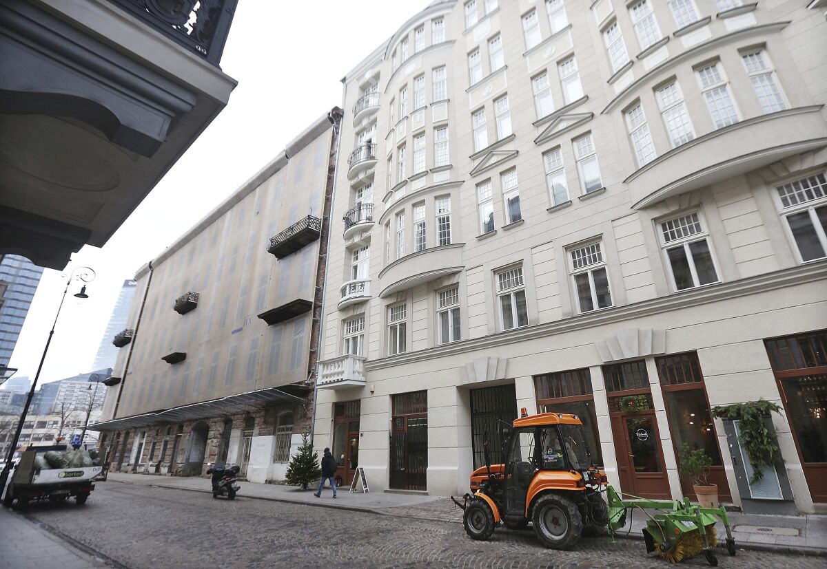 Vehicles are parked along a street in Warsaw.