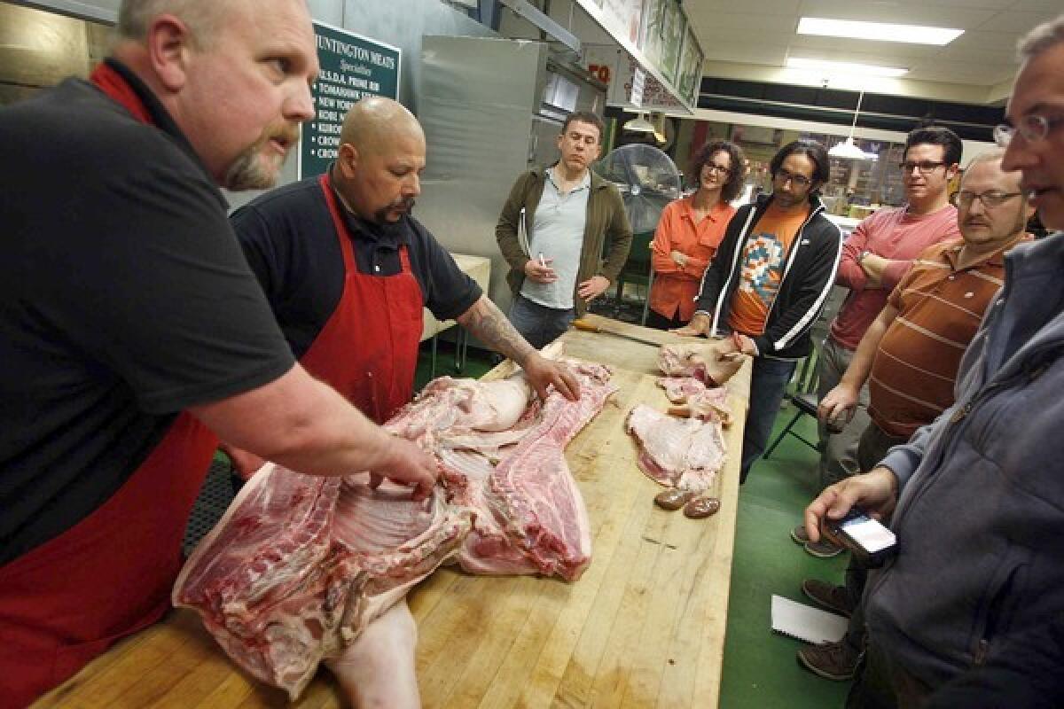 Butchers Bob Ore, left, and John Escobedo conduct a meat-cutting and cooking class at the Huntington Meats.
