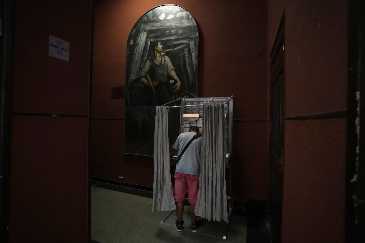 A voter stands in a booth at a polling station.