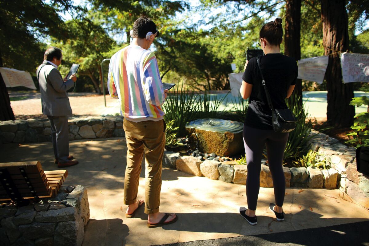 Visitors to a "healing garden" on the Stanford University campus use an augmented-reality app that displays the words of Chanel Miller.