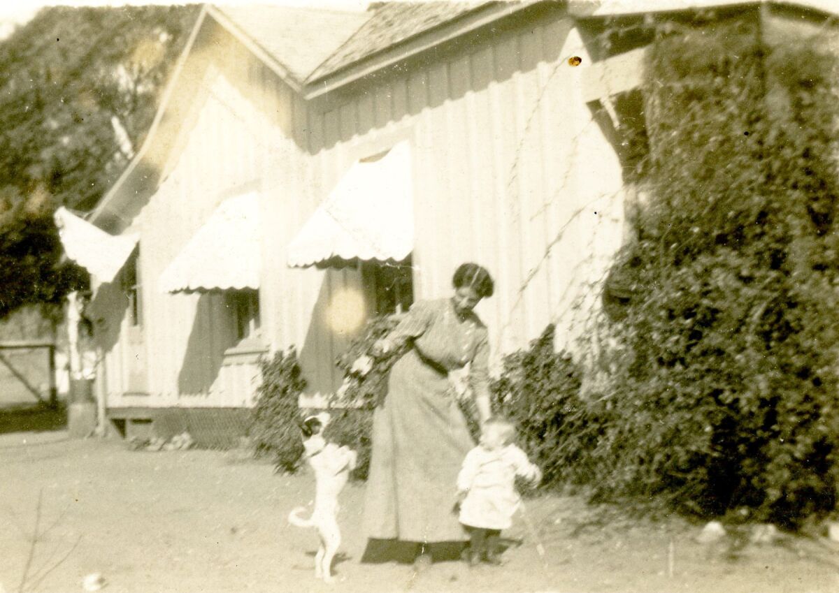 Dolores “Laura” Flint with daughter Hazel and family dog, Ned, outside the Flint home.