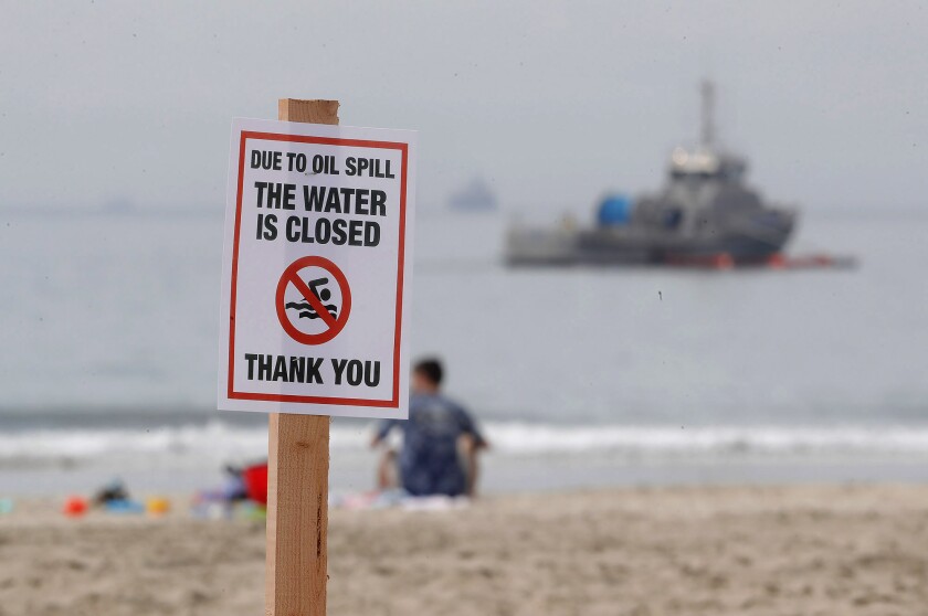 A boat from Marine Spill Response Corp. attempts on Monday to contain an oil spill in Newport Beach.