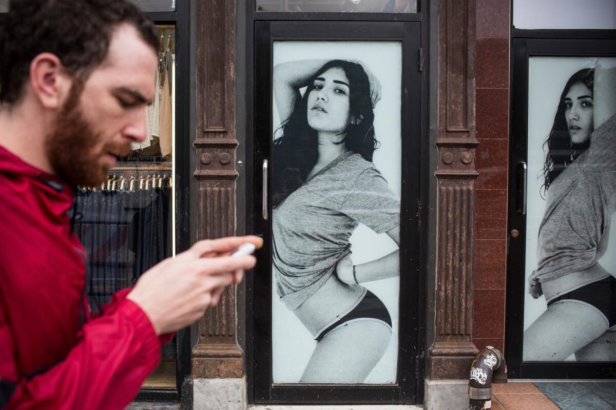 A man walks past an American Apparel store in New York City.