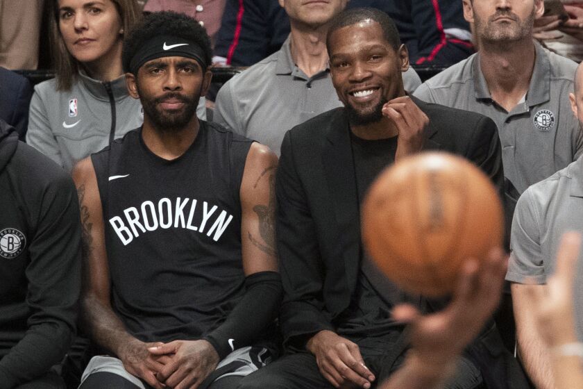 FILE - In this Nov. 1, 2019, file photo, Brooklyn Nets' Kyrie Irving, left, and Kevin Durant watch the game action from the bench during the second half of an NBA basketball game against the Houston Rockets in New York. Kevin Durant asked to leave, though figured he wouldn't. Kyrie Irving wanted to stay, but feared he might be gone. As the chaotic Brooklyn Nets' offseason was unfolding, even the key players struggled to make sense of things as they were happening. Now the Nets are ready to leave it all behind as they begin a new season. (AP Photo/Mary Altaffer, File)