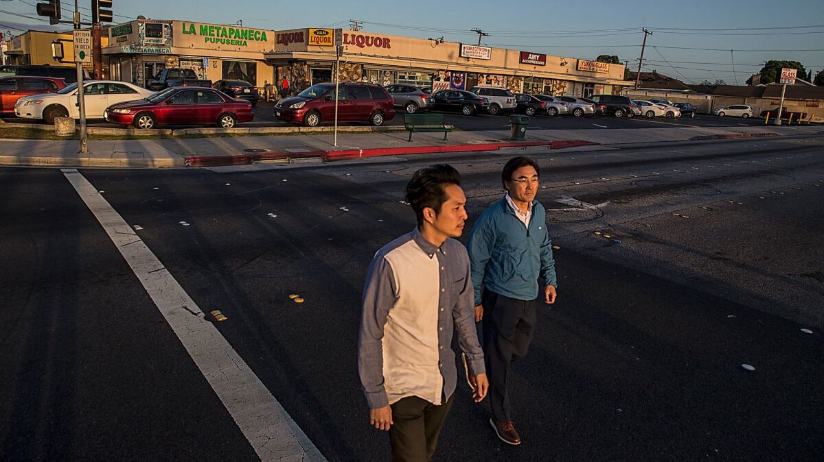 Justin Chon and his father, Sang Chon, cross Van Ness Avenue, one of the sites where Justin filmed the movie "Gook," about the Korean American experience in the L.A. riots of 1992.
