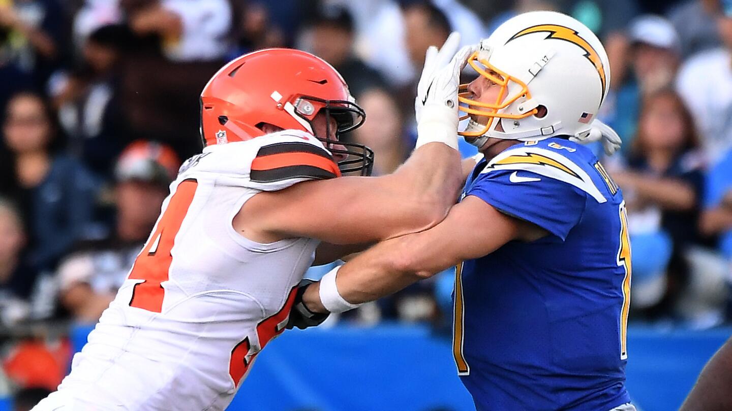 Chargers quarterback Philip Rivers gets a hand to the helmet by Browns defensive lineman Carl Nassib after releasing a pass.