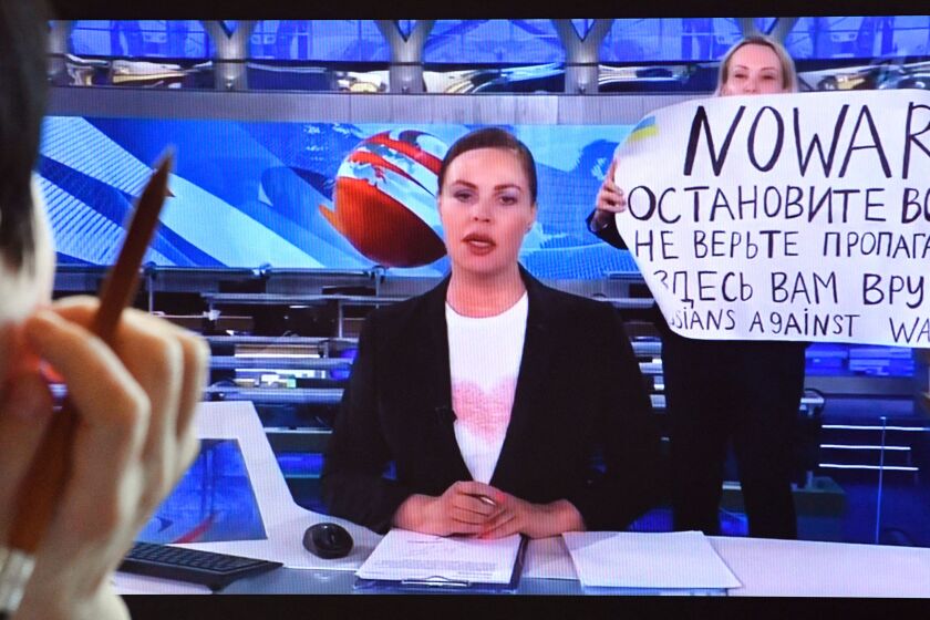 A woman looks at a computer screen watching a dissenting Russian Channel One employee