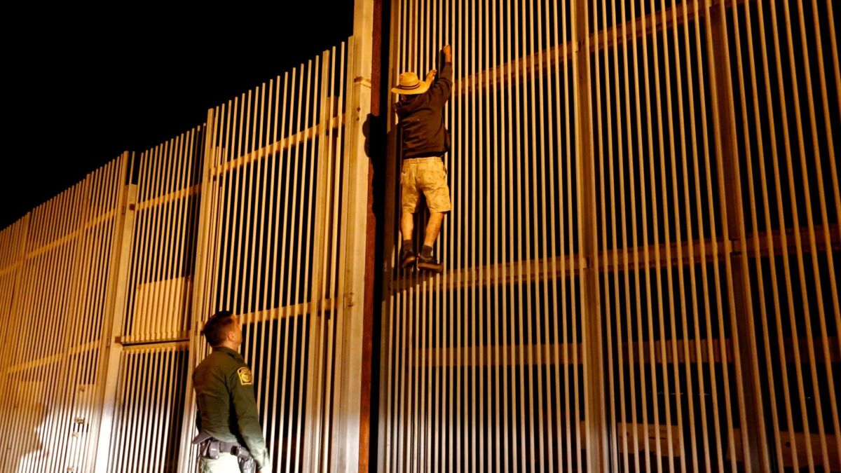 Border Patrol Agent Eduardo Olmos apprehends a Mexican immigrant trying to cross the U.S.-Mexico border in San Diego.