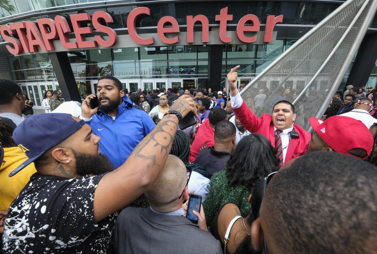 Fans del difunto rapero Nipsey Hussle esperan en línea para entrar al servicio público en su memoria en el Staples Center en Los Ángeles, el jueves 11 de abril del 2019.