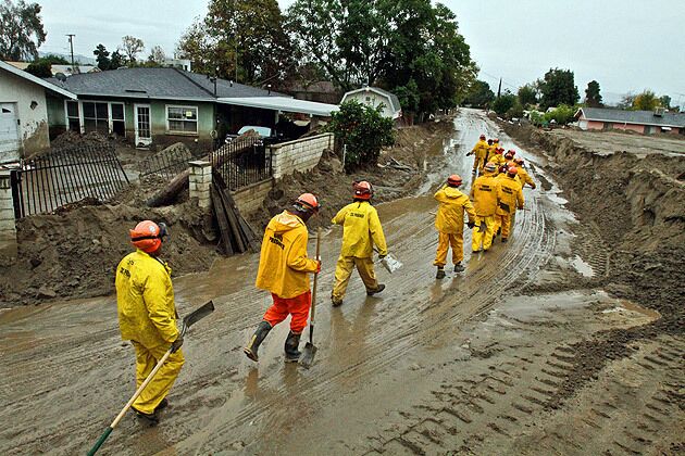 A crew of prison inmates working for the state Department of Forestry and Fire Protection prepares to work to mitigate further rain damage in the San Bernardino County city of Highland. See full story