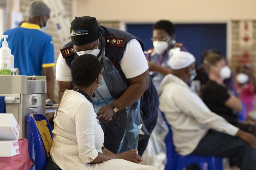 A healthcare worker administers a dose of Johnson & Johnson COVID-19 vaccine to a health staff member at a vaccination center at Chris Hani Baragwanath Academic Hospital in Soweto, South Africa, Friday, March 5, 2021. (AP Photo/Themba Hadebe)