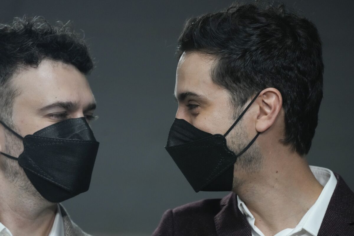 Jaime Nazar, left, and Javier Silva, look at each during a press conference in Santiago, Chile, Thursday, March 10, 2022. Silva and Nazar became one of the first same-sex couples to be joined in matrimony on Thursday following the recent signing into a law welcoming same-sex marriage in Chile. (AP Photo/Natacha Pisarenko)