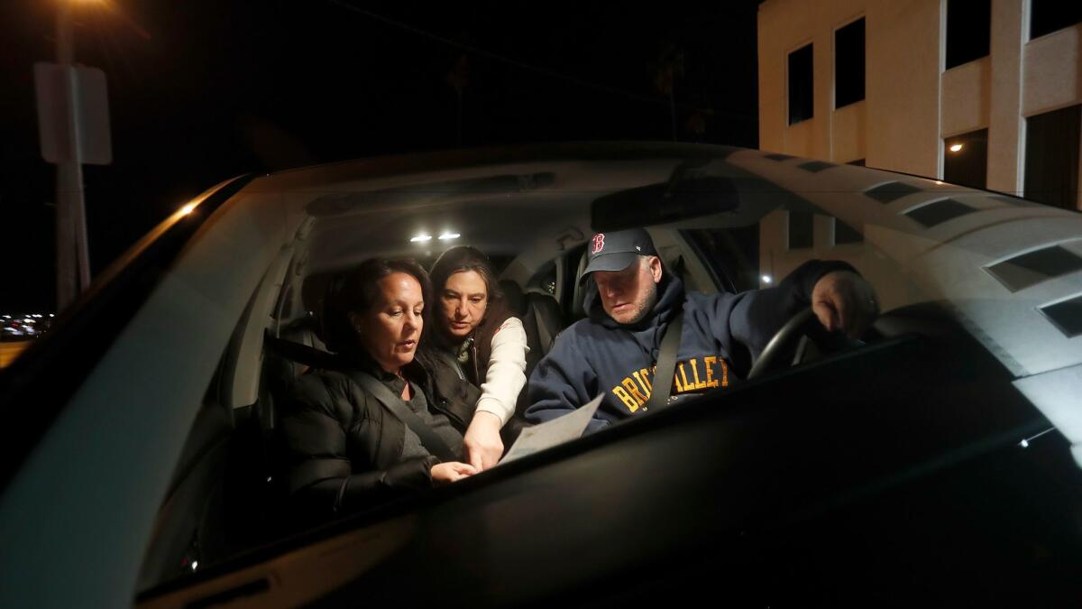 Volunteers Kathy Creighton, left, and her husband, Ken Creighton, are joined by Kamara Shephard as they figure out directions on a map of San Pedro during L.A. County's homeless count Wednesday. (Luis Sinco/Los Angeles Times)