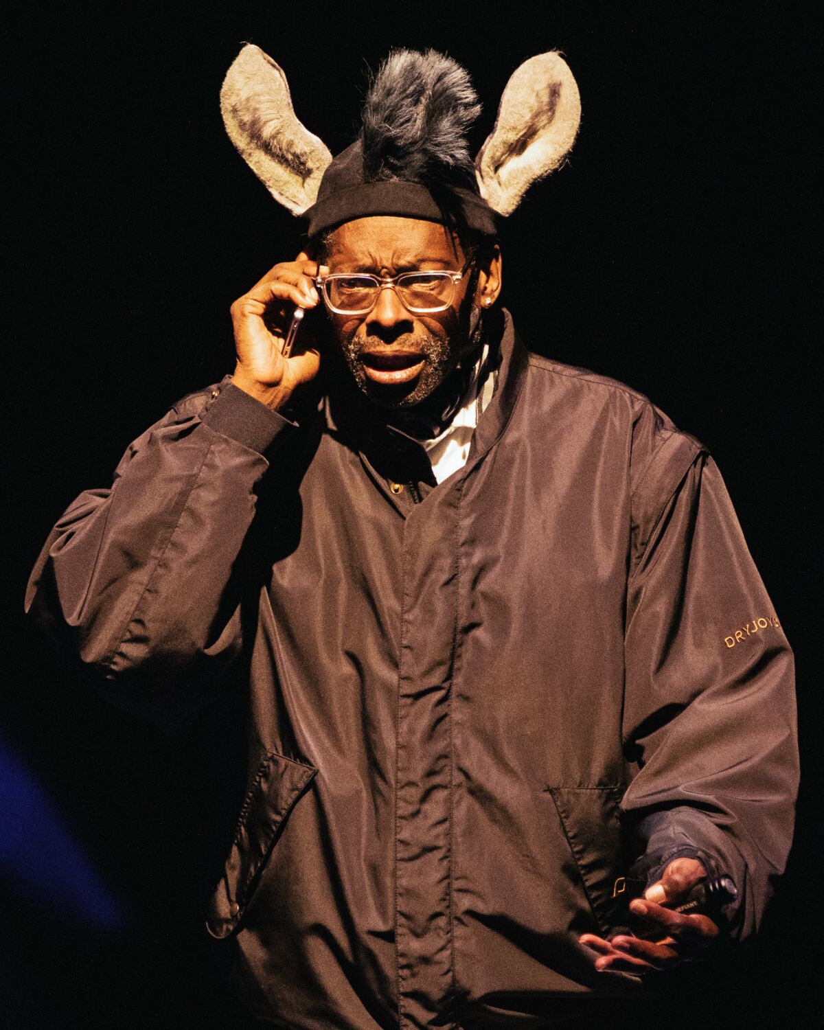 A man wears a brown coat and animal ears.