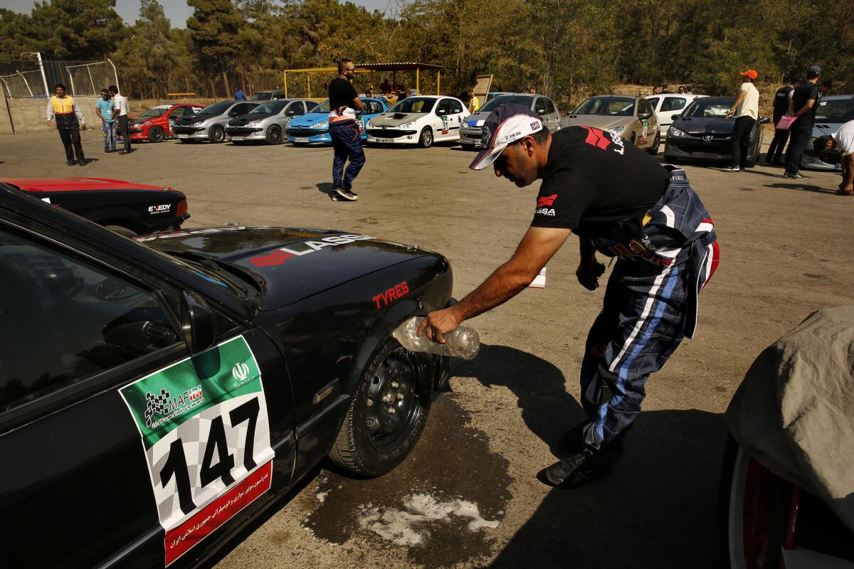 A driver rinses his tires before a race at a Tehran racetrack, where enthusiastic drag racers meet almost every Friday.
