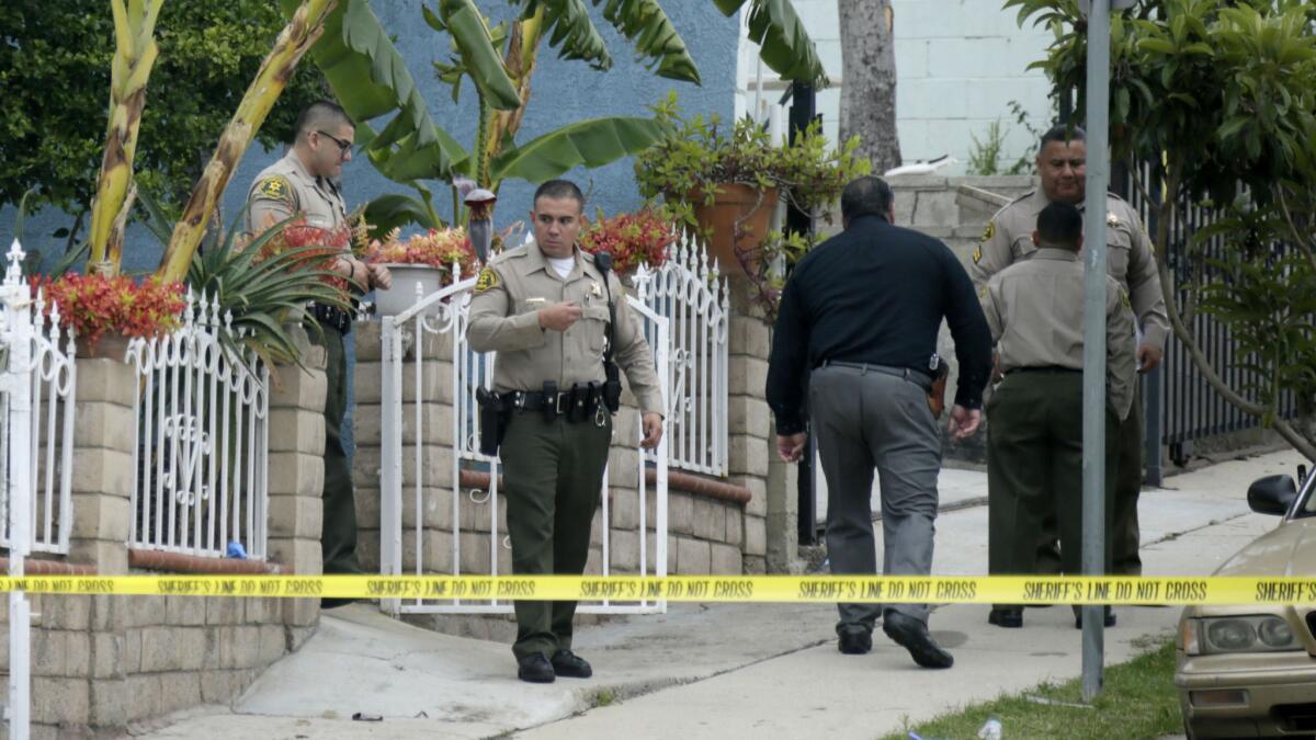 Los Angeles County sheriff's deputies and investigators at the scene where a woman was attacked by a man with a hammer in East Los Angeles early Wednesday.