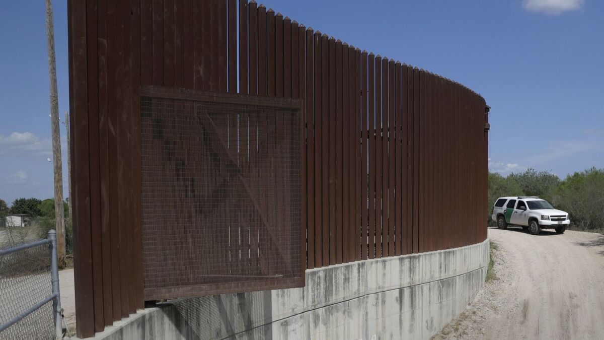 A U.S. Customs and Border Patrol vehicle passes along a section of border levee wall in Hidalgo, Texas, last year.