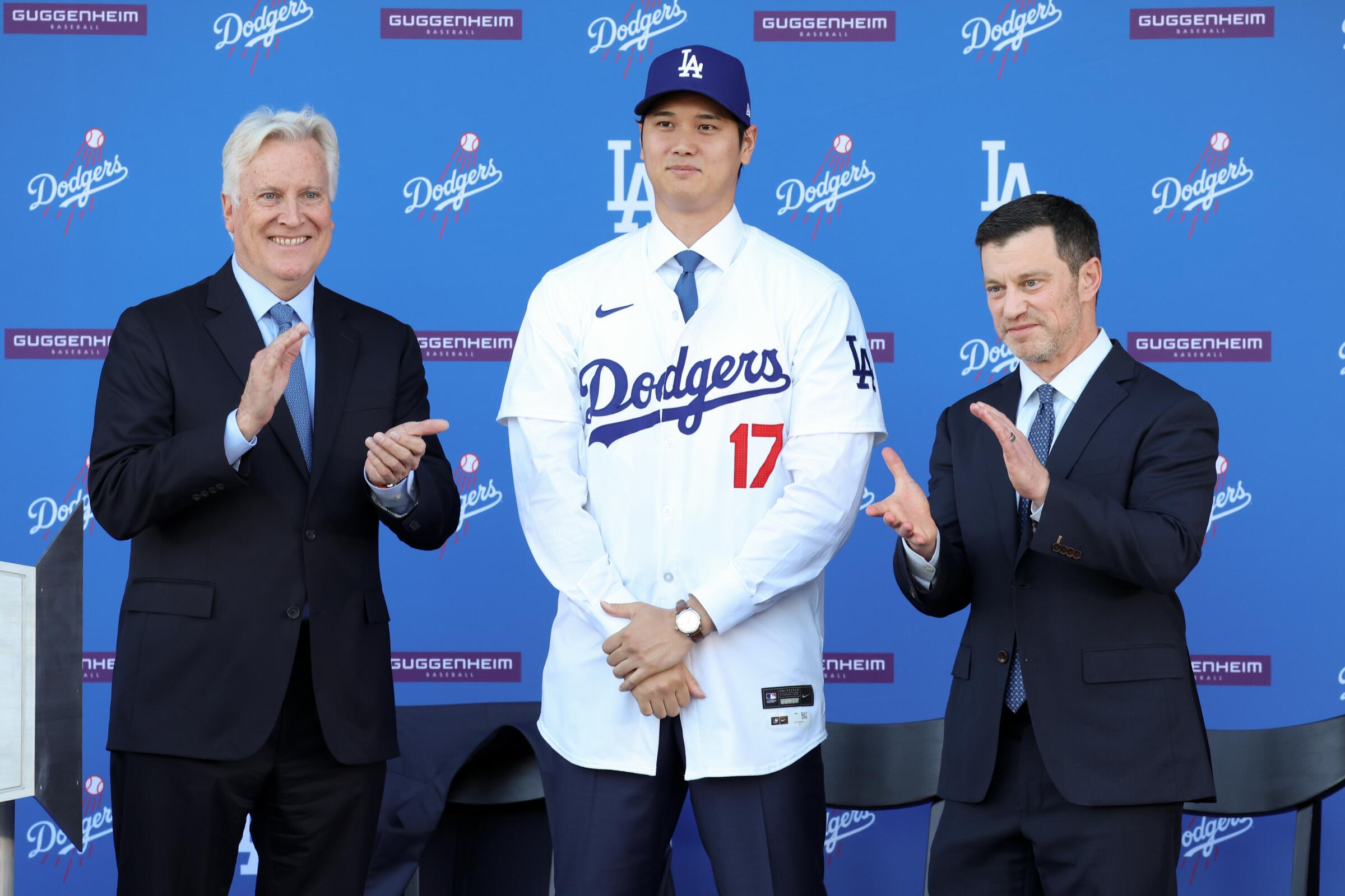 Shohei Ohtani stands between Dodgers owner Mark Walter, left, and Andrew Friedman.