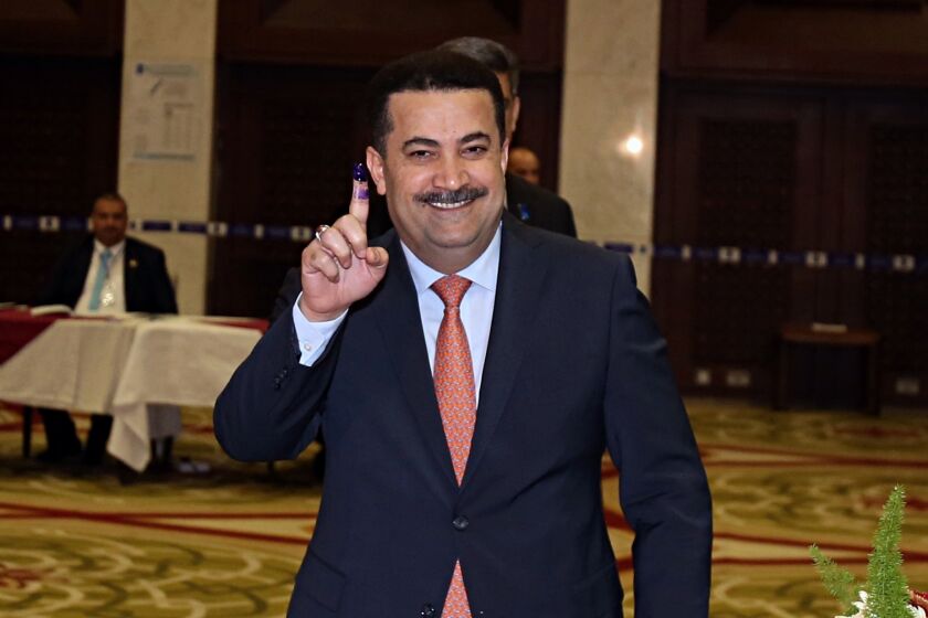 FILE - Mohammed Shias al-Sudani, Minister of Labor and Social Affairs shows his ink-stained finger after casting his vote in the country's parliamentary elections in the heavily fortified Green Zone in Baghdad, Iraq, Saturday, May 12, 2018. Iraq's Prime Minister Mohammed Shia al-Sudani said in a statement on Sunday Nov. 27, 2022, it will recover part of nearly $2.5 billion in funds embezzled from the country's tax authority in a massive scheme involving a network of businesses and officials. (AP Photo/Karim Kadim, File)