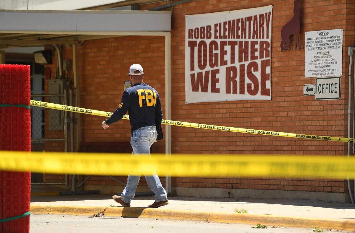 An FBI agent walks outside Robb Elementary School.