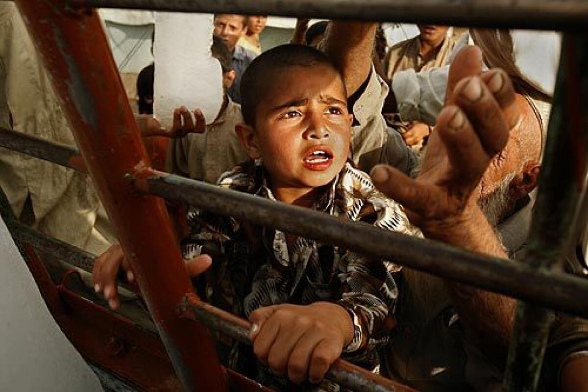 A 10-year-old boy, Anwar Khalil, waits to get a chunk ice at the Swabi camp where about 20,000 people displaced from Swat are living in tents in extreme heat, without water or power. They are forced to queue for hours for food. Some refugees, nearly all Pashtuns, have made their way to other parts of the country, such as Karachi, where tension with other ethnic groups is surfacing.