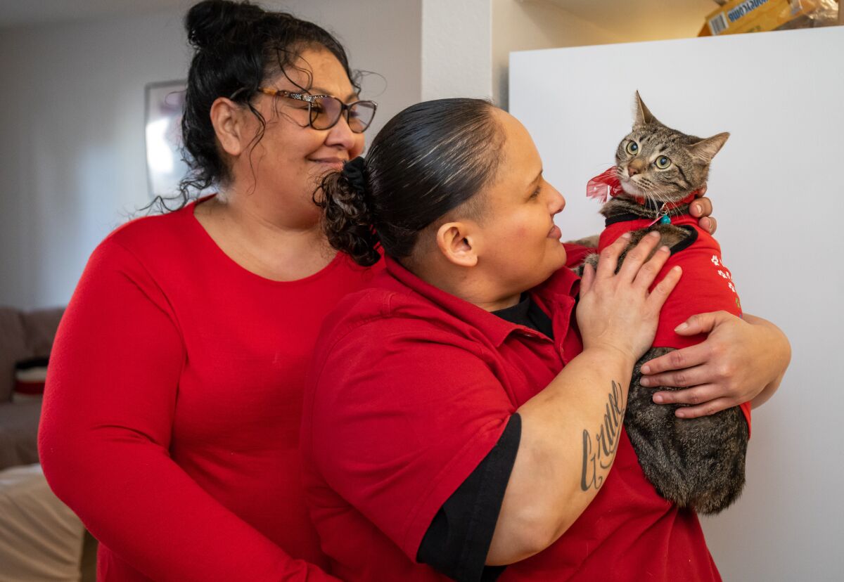  Graciela Meraz and Carolyn Rodriguez are shown with their cat, Lam Lam. 