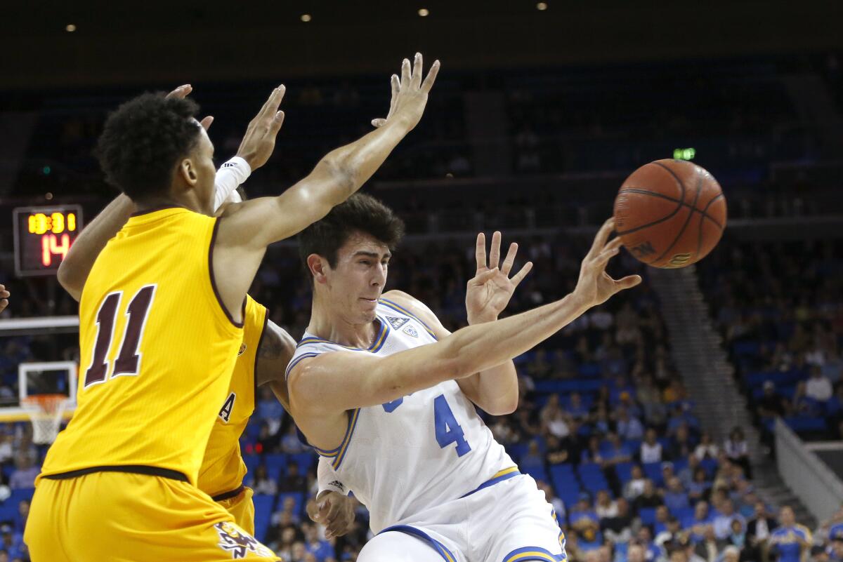 UCLA guard Jaime Jaquez Jr. (4) passes the ball while defended by Arizona State players during the first half on Thursday at Pauley Pavilion.
