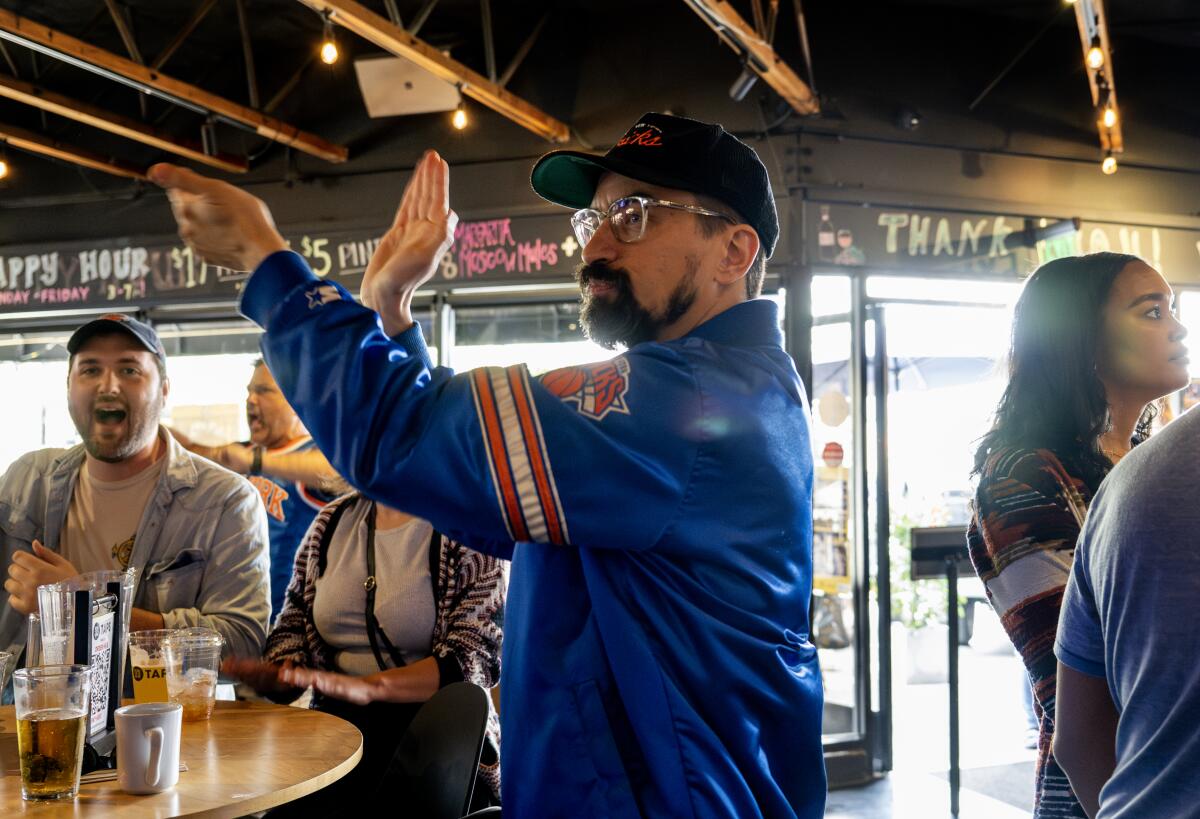 New York Knicks fan Peter Agoston cheers on his team while watching a game against the Miami Heat at a bar.