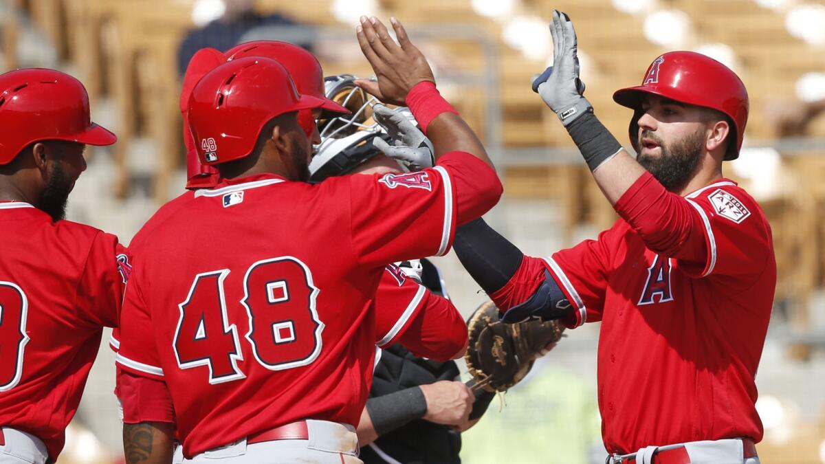 Kaleb Cowart, right, gets high-fives from his Angels teammates after hitting a grand slam against the Chicago White Sox on Monday.
