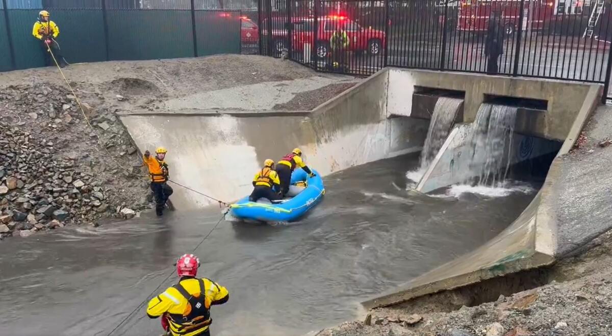 Orange County Fire Authority's swift water rescue team rush to pull a man trapped in a storm drain.