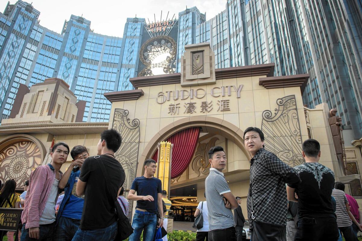People wait outside the Studio City casino-resort ahead of its opening in Macau. Casino operator Melco Crown Entertainment built its latest resort as Macau scrambles to attract mass-market visitors amid falling gambling revenue.