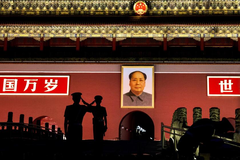 Chinese paramilitary police salute each other as they stand guard beneath a portrait of the late leader Mao Tse-tung in Tiananmen Square on Wednesday.
